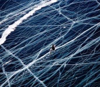 Lake Baikal - Siberia -Horse rider crossing frozen Lake Baikal and white lines are cracks in the ice.